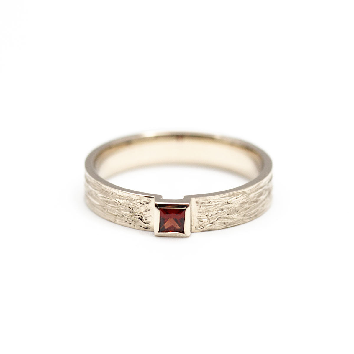 Bague de fiançailles pour homme créée sur-mesure en or blanc 18 carats, sertie d'un grenat Idaho rouge. Bijou crée et fabriqué par nos artisans joailliers à Paris