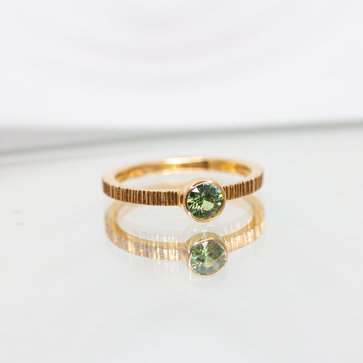 Bague originale avec en son centre un grenat vert, réalisée en or rose-champagne Fairmined 18 carats. 