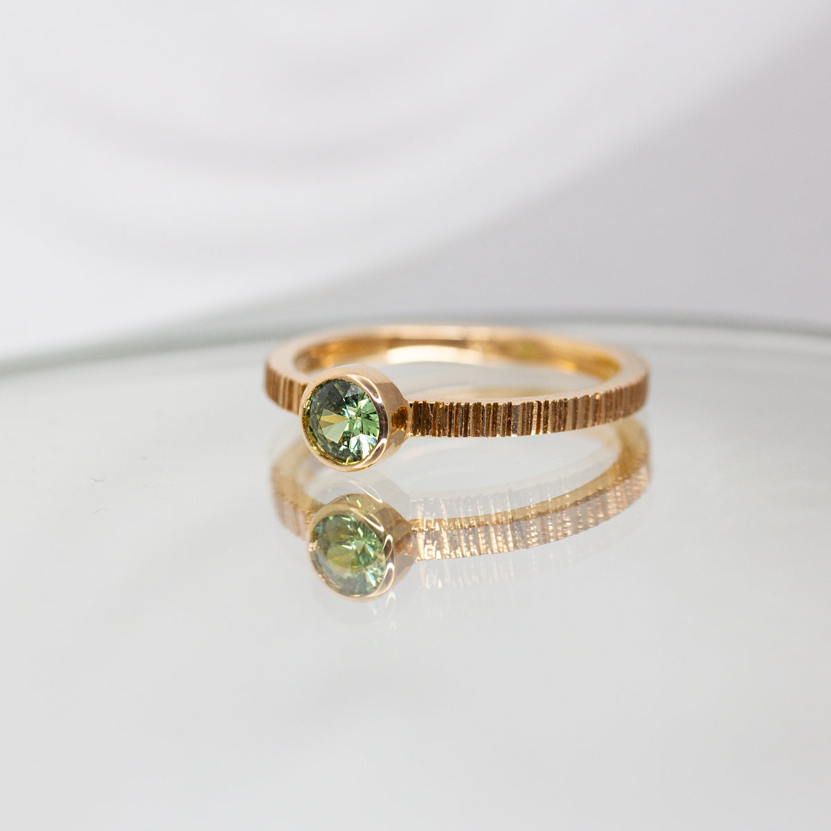 Bague en or 18 carats Fairmined,avec un grenat vert en son centre. 