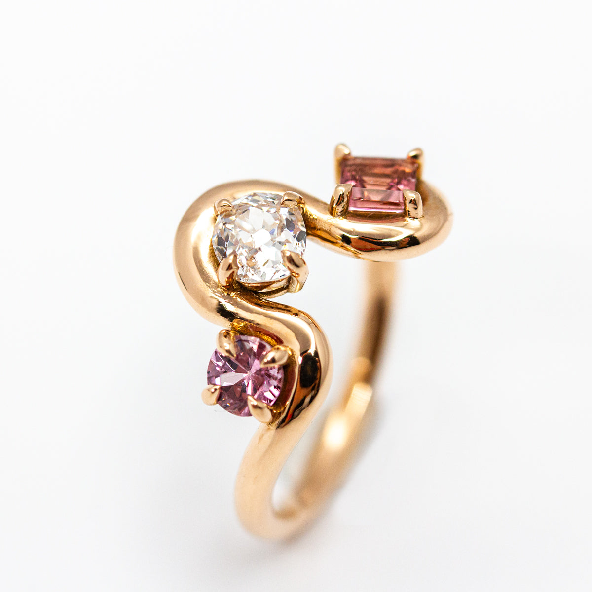 Bague organique sur mesure en or rouge 750/1000, anneau ondulé serti d'un diamant et de pierres fines roses. Bijou de créateur fabriqué artisanalement à paris