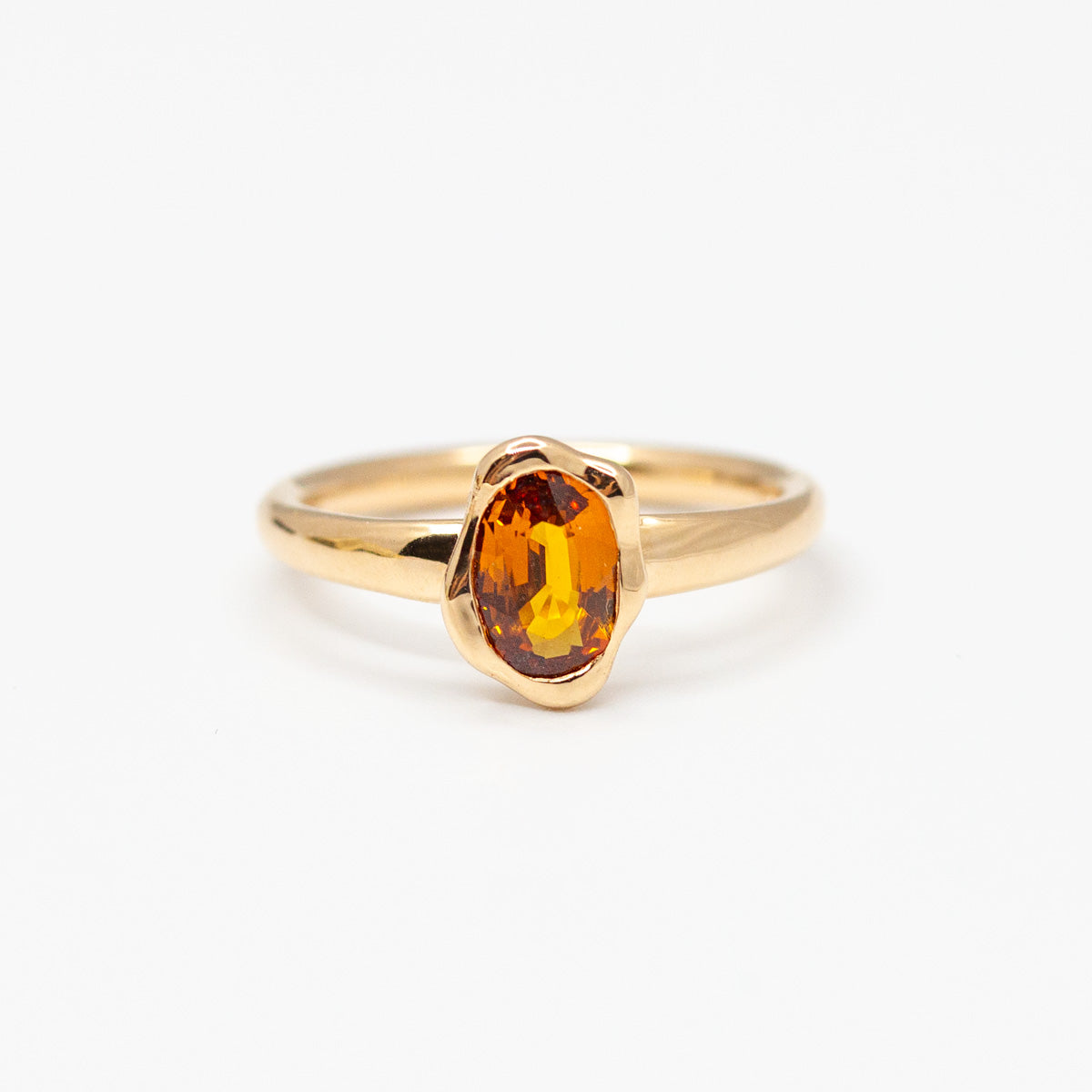Sur-mesure : Solitaire saphir orange ovale orné d'un serti organique, fabriqué artisanalement en or 750/1000 Fairmined