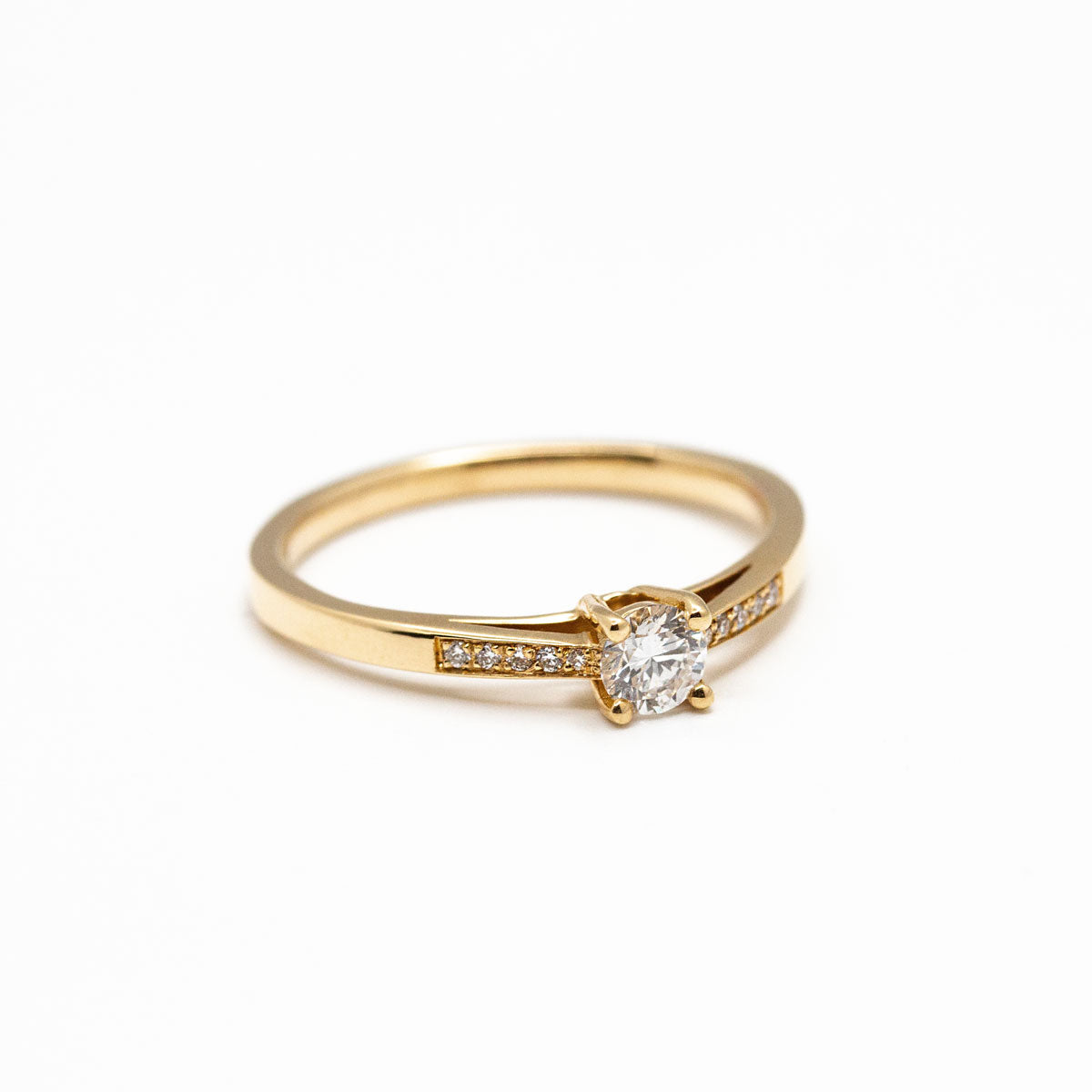 Bague de fiançailles pavée femme sertie d'un diamant central de 5mm et 10 diamants de synthèse en or rose champagne recyclé 750/1000 + prime Fairmined. Fabriquée avec savoir-faire à la main dans notre atelier de joaillerie à Paris
