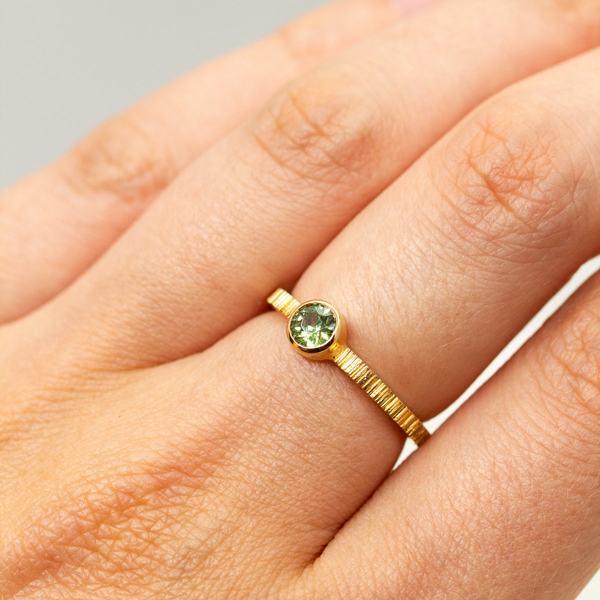 Bague en or 18 carats avec un grenat vert en son centre.