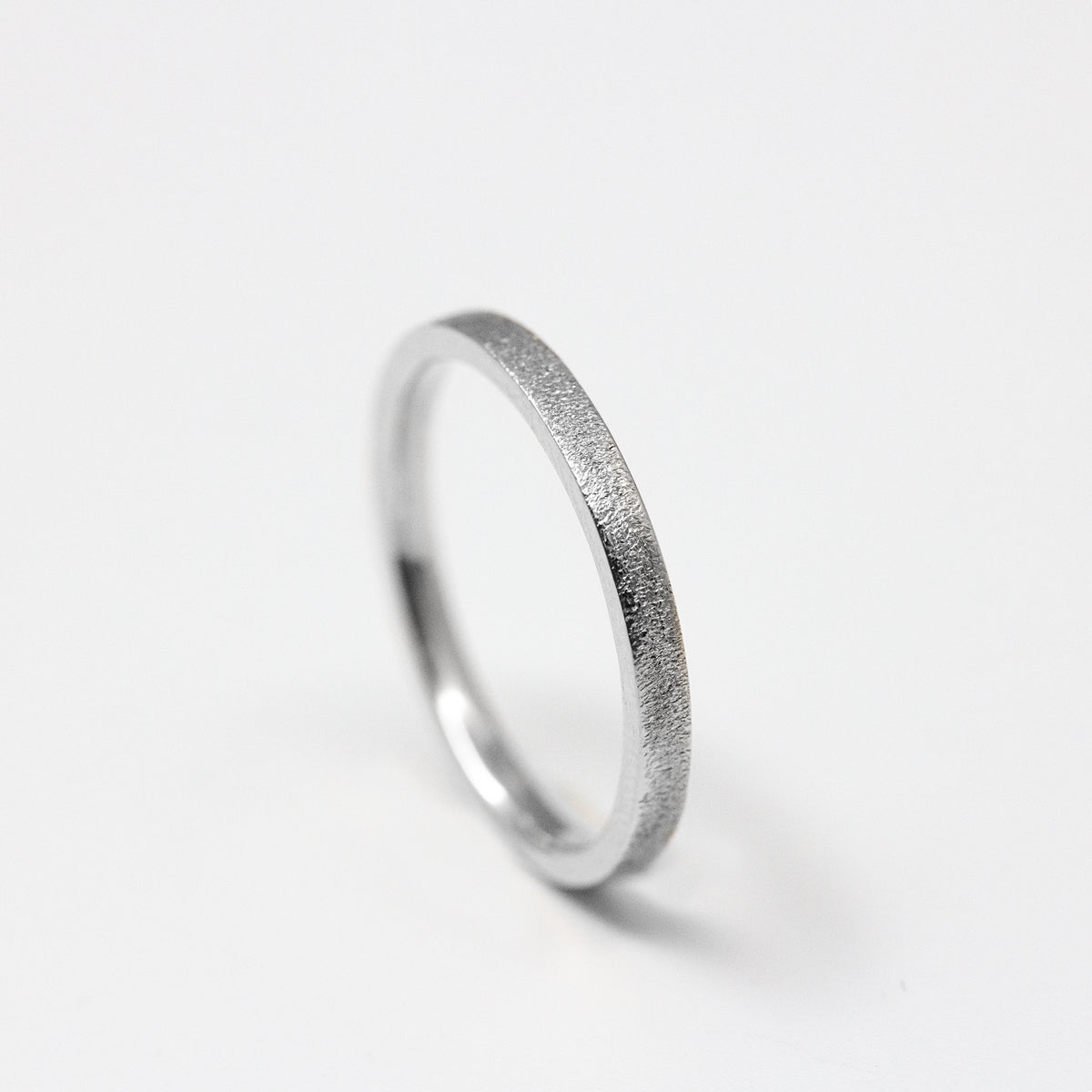 Alliance fine femme en or blanc recyclé 18 carats, texture givrée Gina ruban 2 mm. Fabrication artisanale & joaillerie éthique