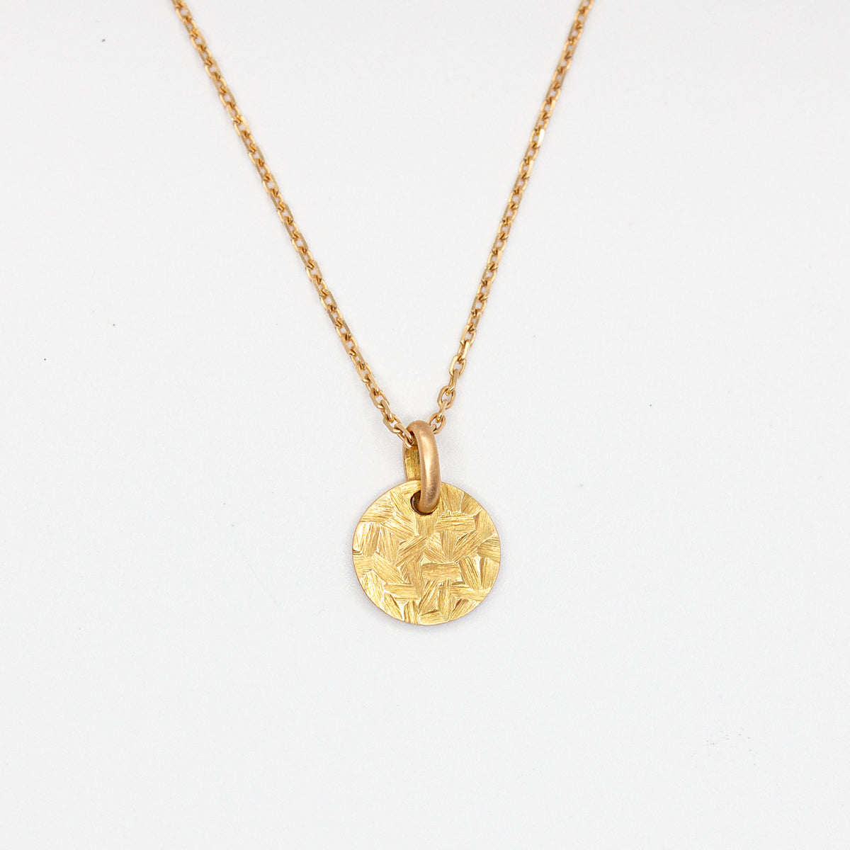 Médaille ronde de 10mm en or jaune 750/1000 martelé artisanalement dans notre atelier de joaillerie éthique. Bijou à offrir pour les baptêmes, naissances, anniversaires