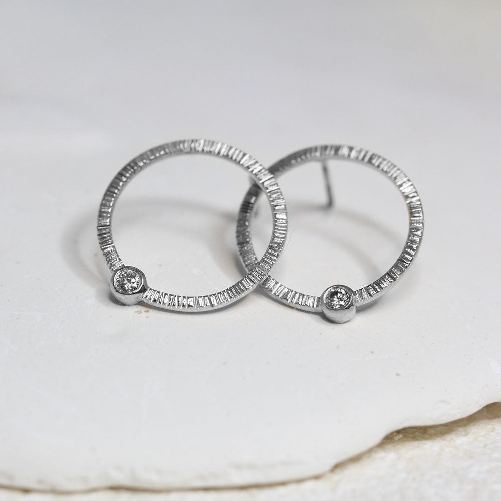 Boucles d'oreille en or blanc Fairmined réalisées dans un atelier de joaillerie artisanale.