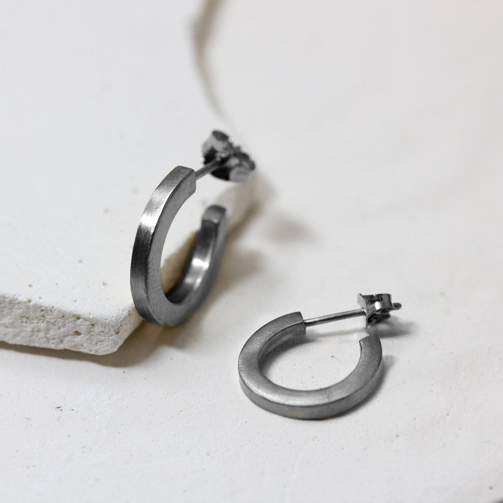 Boucles d'oreille réalisées en or gris palladié dans un atelier de joaillerie artisanal.