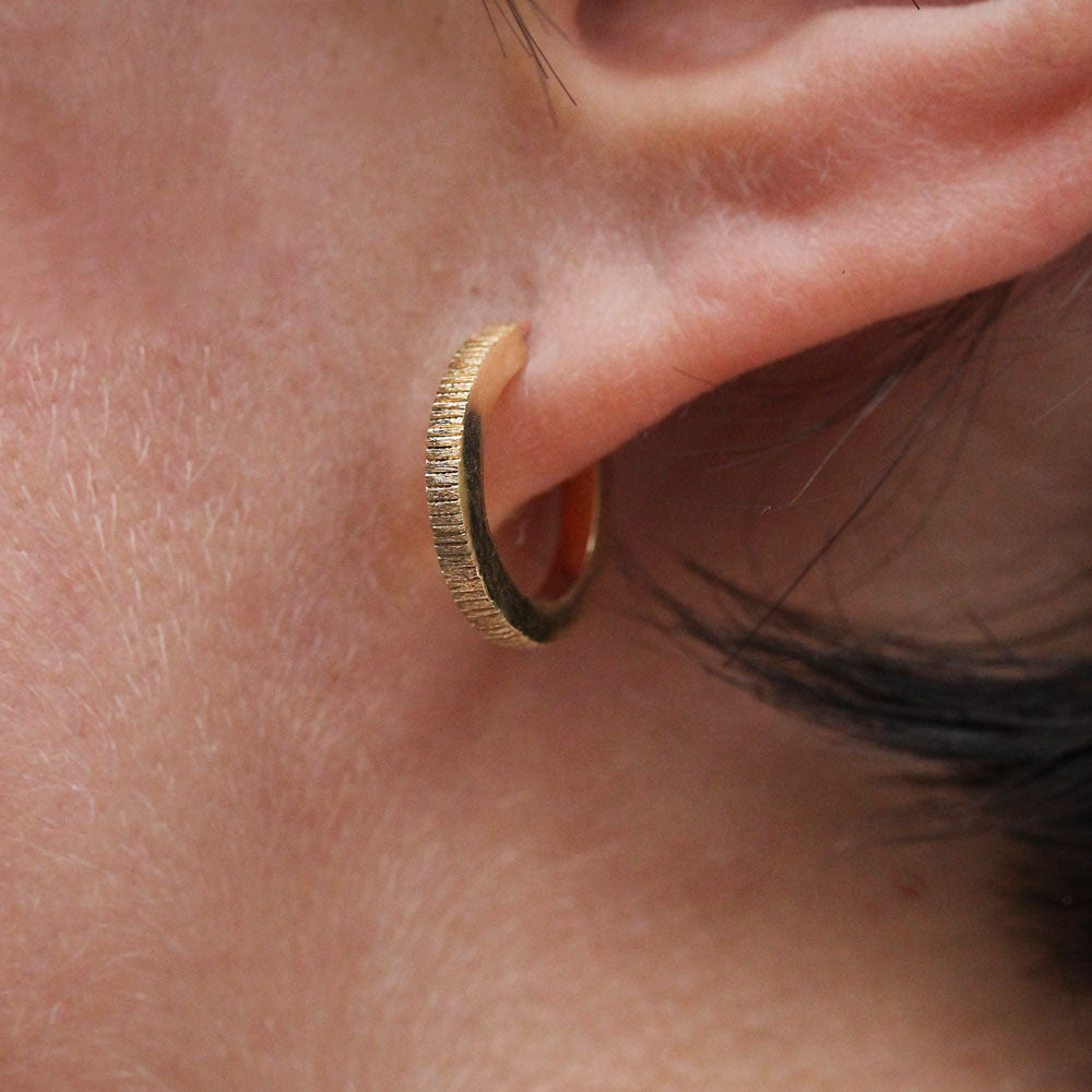 Boucles d'oreille texture Isandre, réalisées dans un atelier de joaillerie artisanale à Paris.