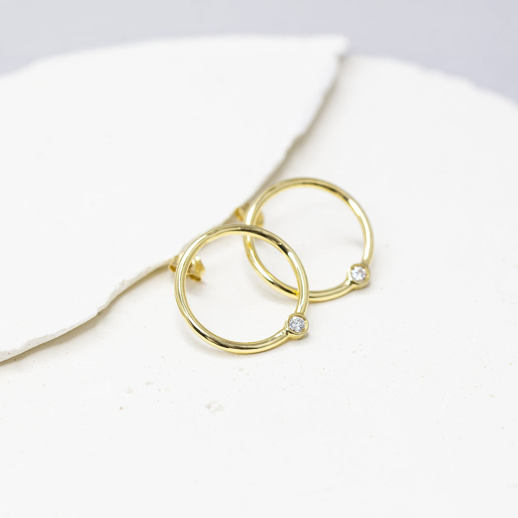 Boucles d’oreilles rondes en or jaune Fairmined 750/1000, qui se déposent délicatement sur le lobe, serties d’un diamant.