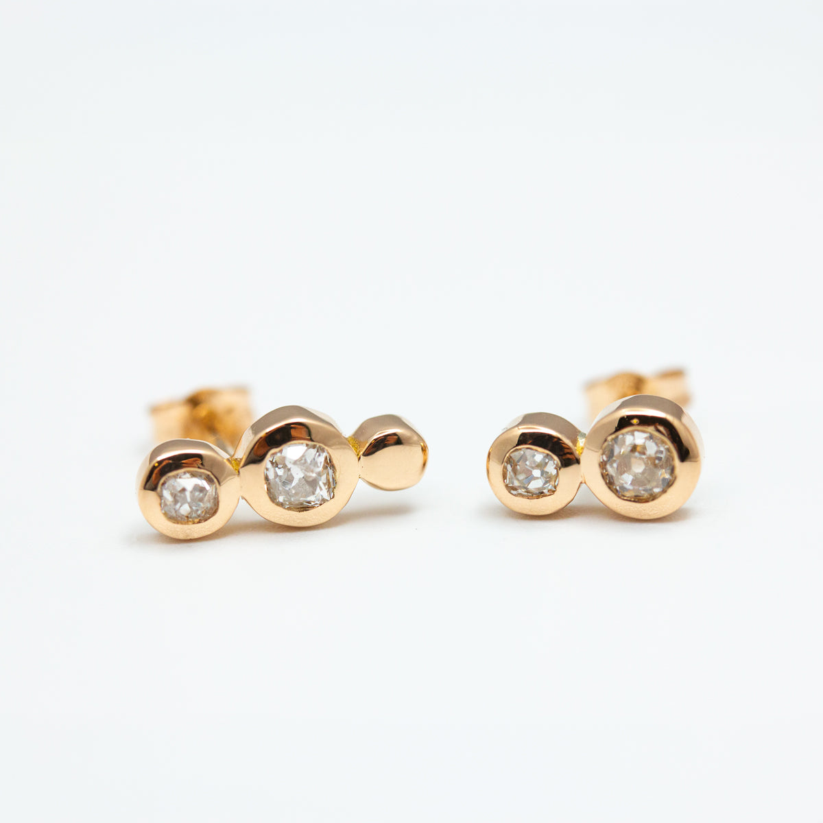 Boucles d'oreilles asymétriques créées sur-mesure à partir de diamants de famille et or équitable Fairmined.