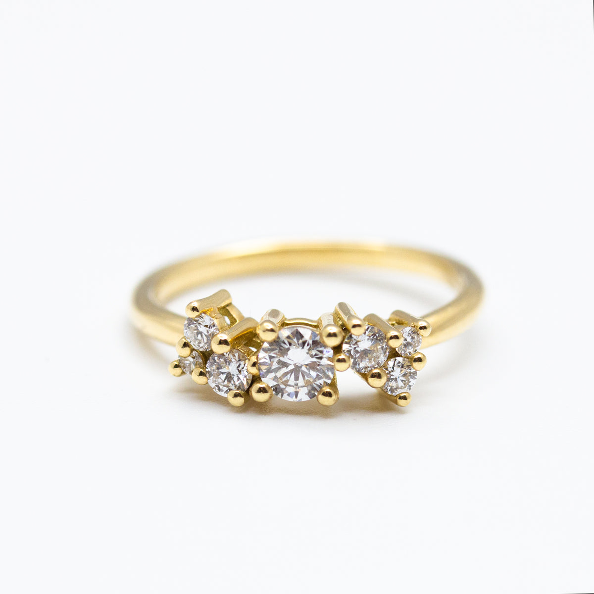 Bague de fiançailles asymétrique et éthique en or jaune 18 carats ornée de diamants de synthèse. Personnalisable en ligne avec saphirs bleu-vert certifiés Fair Trade. Joaillerie éthique et fabrication artisanale