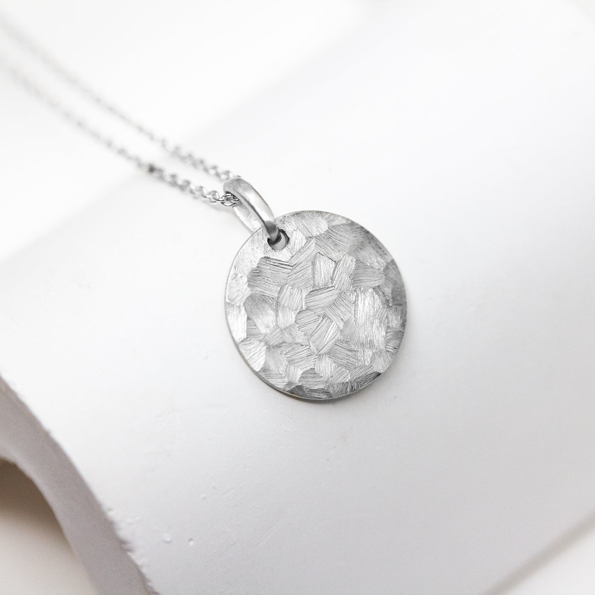 Collier avec une médaille texturée en or blanc Fairmined 18 carats.