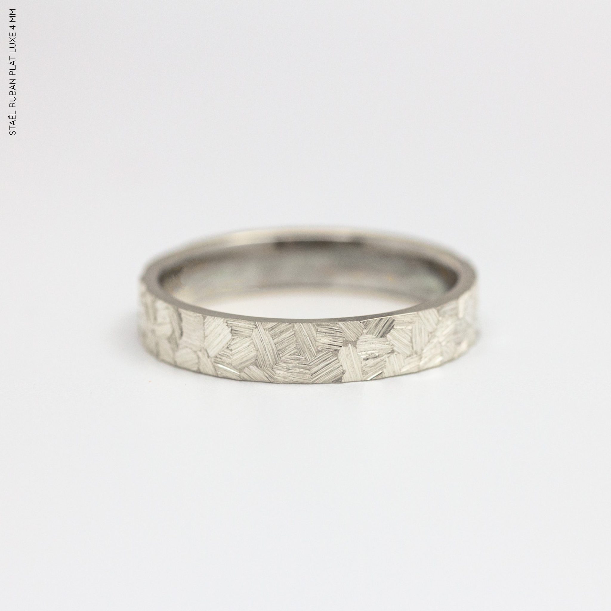 Alliance artisanale homme en argent rhodié ruban 4mm texture brossée Staël.
Bague mariage et union en argent 925/1000
Alliance fabriquée dans notre atelier parisien par nos joaillères de façon artisanale.