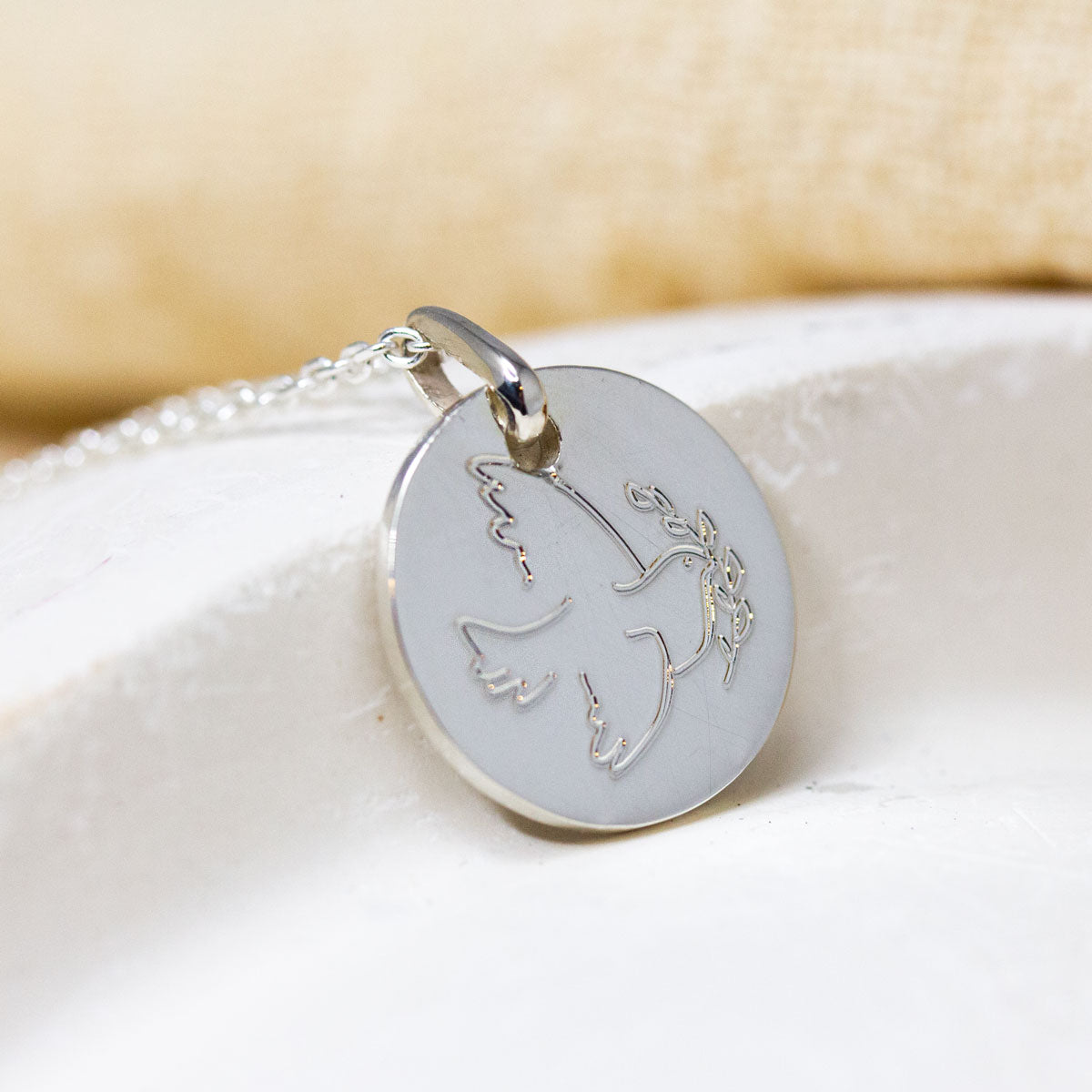 Médaille en or blanc, joaillerie artisanale made in France.