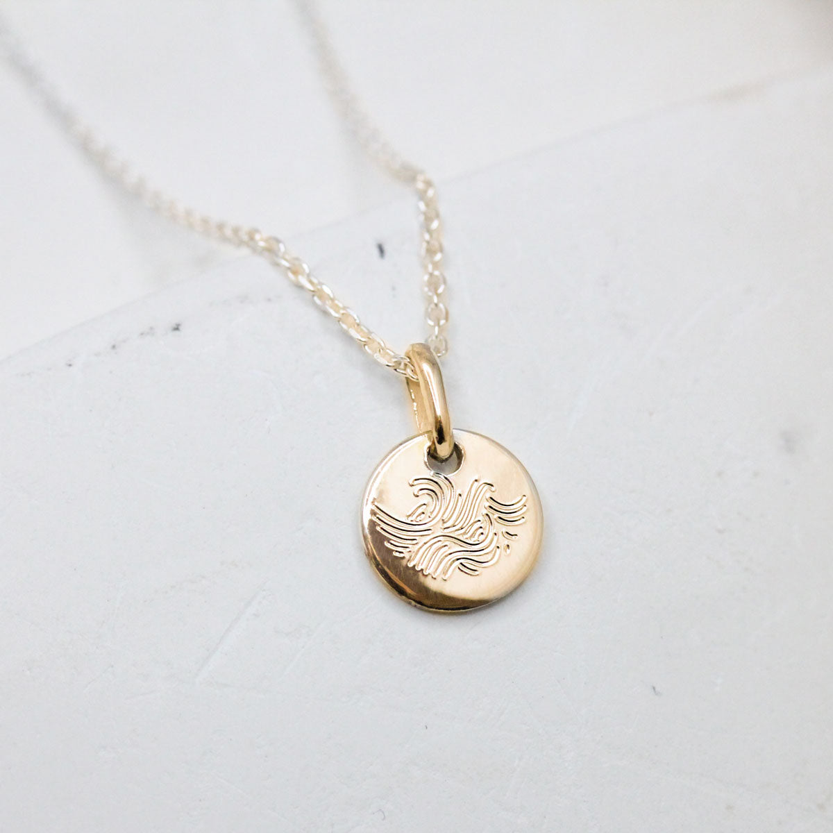 Médaille en or rose-champagne éthique Fairmined réalisée dans un atelier de joaillerie à Paris.