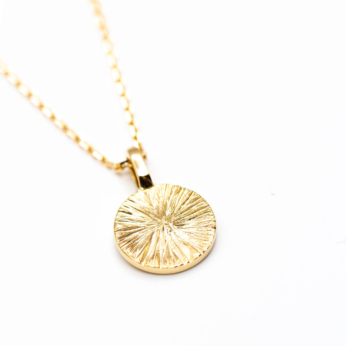 Médaille Arsène ronde 10 mm en or recyclé 18 carats + prime Fairmined réalisée à la main à Paris par nos joailliers, motifs de soleil strié 