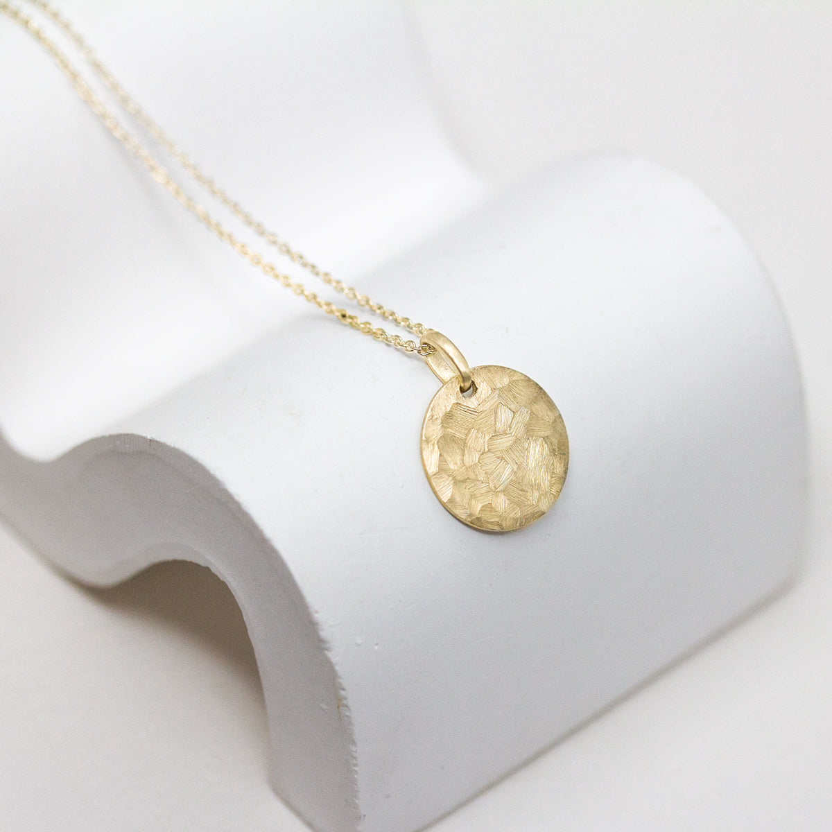 Médaille texturée en or jaune Fairmined 18 carats fabriquée dans notre atelier à Paris.