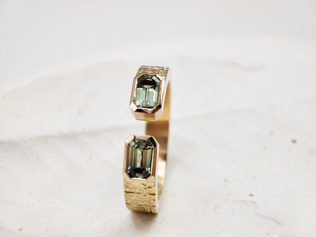 Bague sur-mesure en or éthique 18 carats Fairmined et ses deux saphirs verts. Bijoux éco-responsables façonnés dans notre propre atelier de joaillerie à Paris