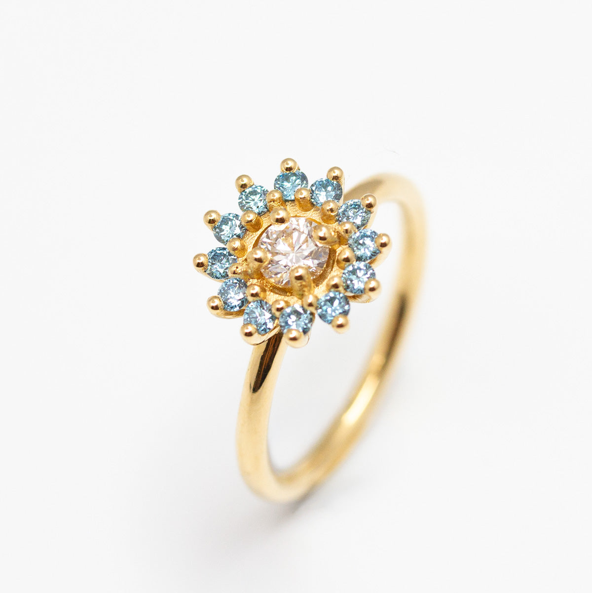 Bague Marguerite diamant 4mm, diamants bleus de 1,8mm et or jaune Fairmined 
Fabrication artisanale à Paris dans notre atelier de joaillerie éthique 