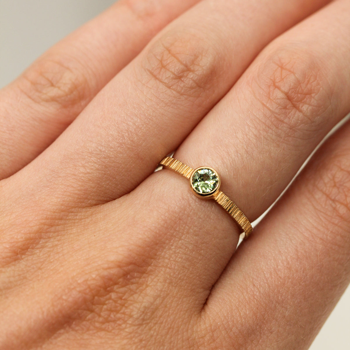 Bague en or rose-champagne sertie d'un grenat vert.