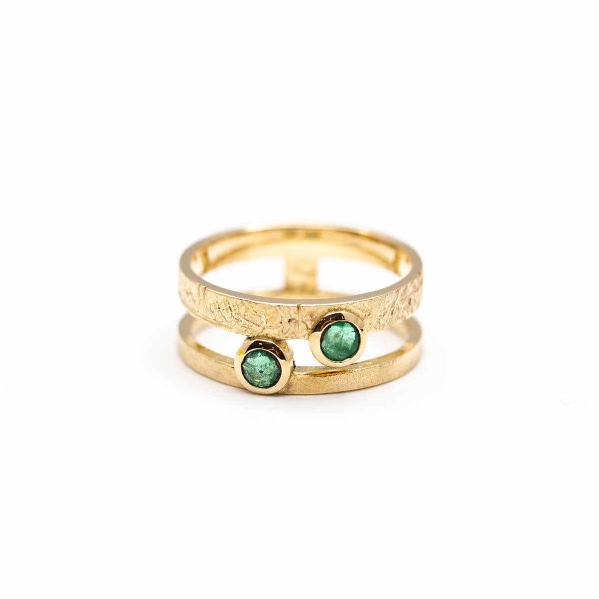 Bague double-anneau sur-mesure, anneau de 2,5mm et 1mm en or 750/1000 texturé sertis de deux pierres vertes de famille. Création artisanale fabriquée et imaginée à Paris