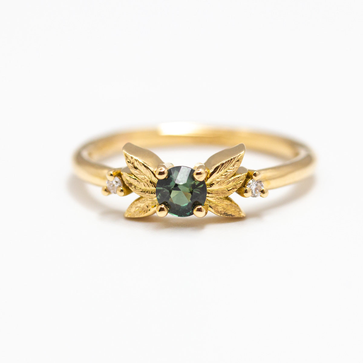 Sur-mesure : Bague feuilles d'or et saphir vert épaulée de deux diamants de synthèse, fabriquée en or 750/1000 Fairmined
Conception de bijoux sur-mesure et éthiques à Paris