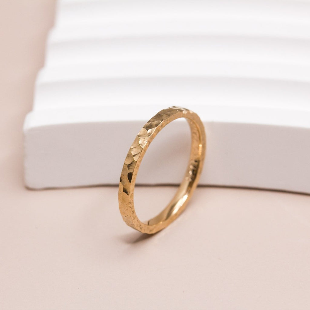 Alliance en or éthique texturée sur l'anneau.