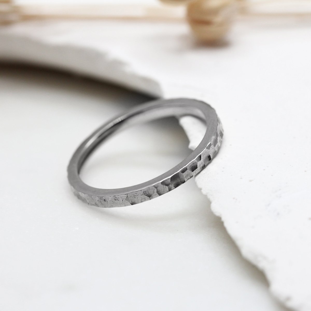 Alliance de mariage martelée en or gris palladié éthique Fairmined. Fabriquée à Paris dans notre atelier de joaillerie.