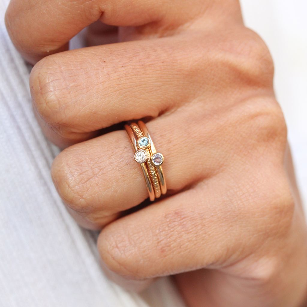 Accumulation de bagues en or éthique 18 carats Fairmined ornées de pierres précieuses.