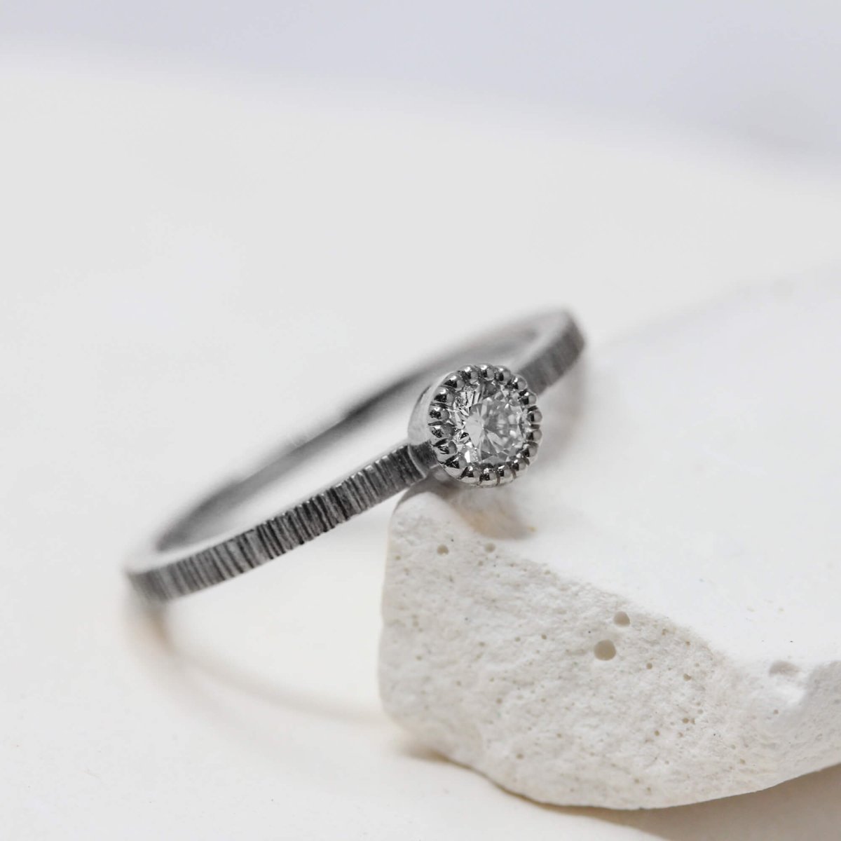 Bague de fiançailles originale en or gris palladié 18 carats Fairmined et ornée d'un diamant.