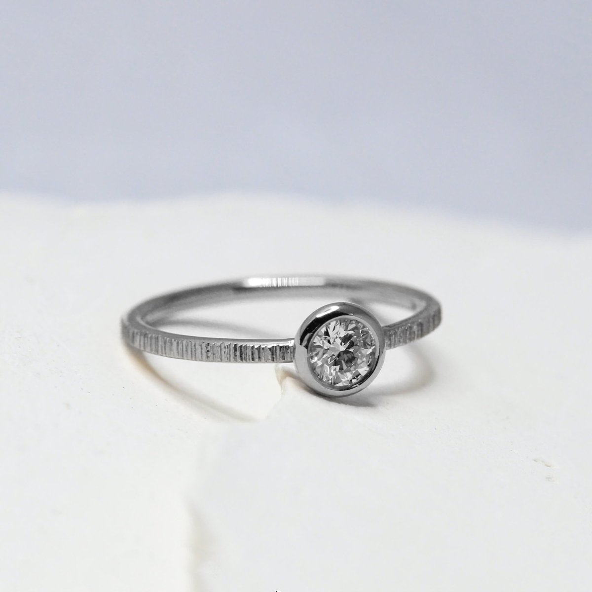 Bague de fiançailles originale en or gris palladié Fairmined, ornée d'un diamant.