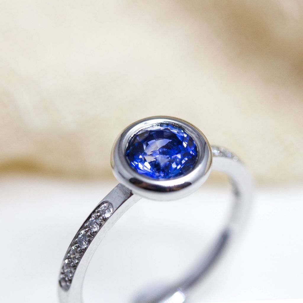 Bague de fiançailles avec saphir bleu intense et diamants de synthèse.