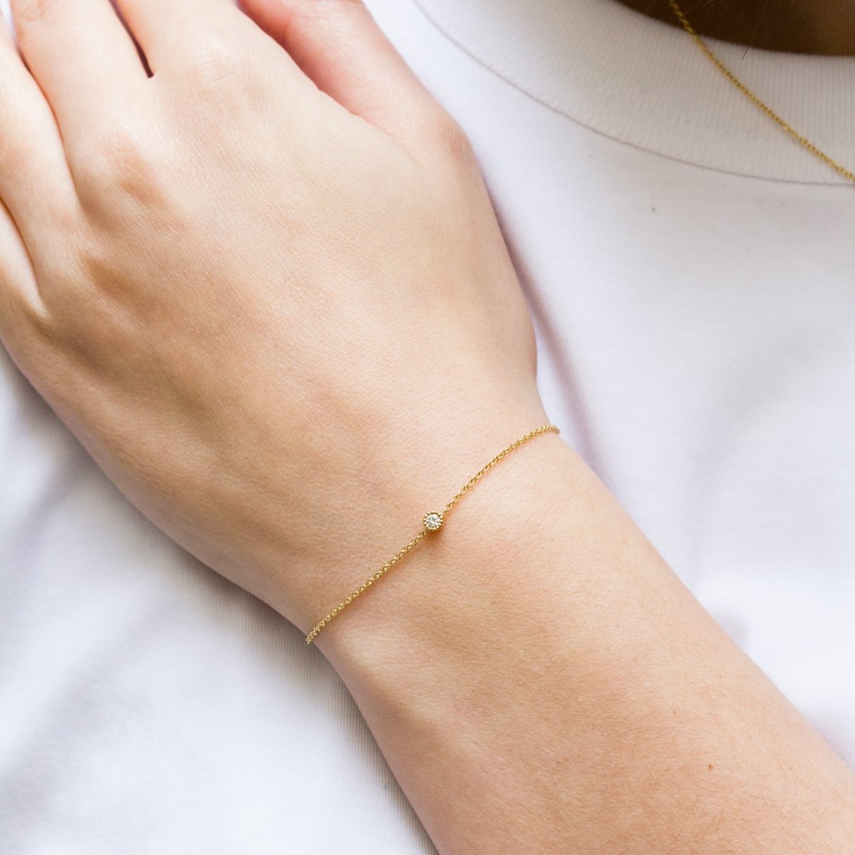 Bracelet en or orné d'un diamant au centre.