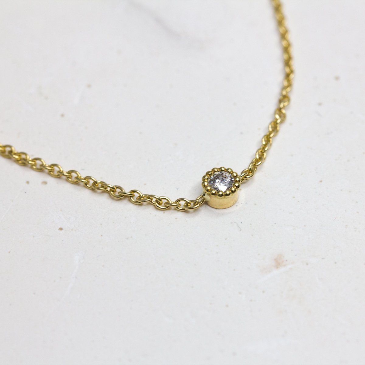 Bracelet en or jaune avec un diamant de synthèse au centre.