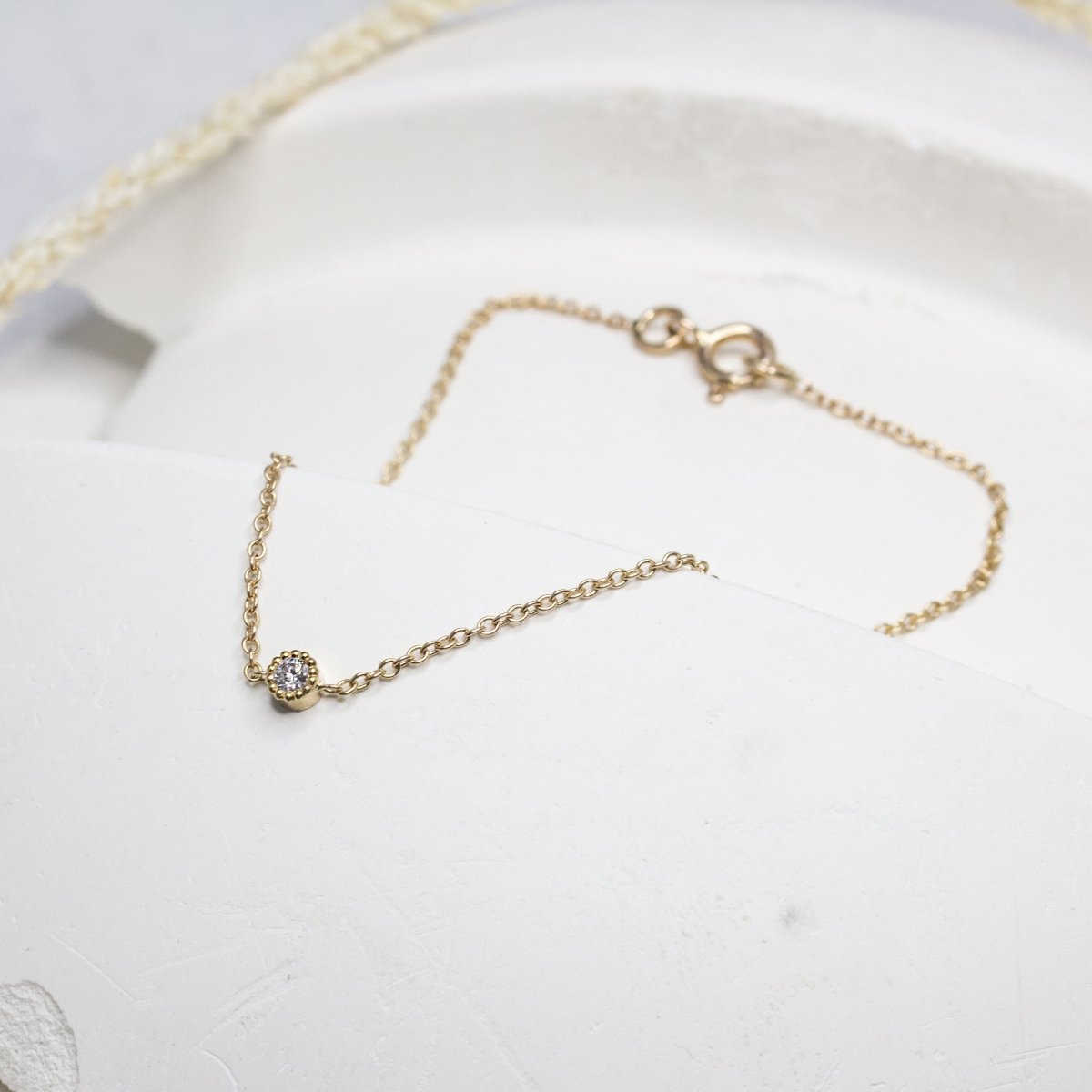 Bracelet avec une chaîne très fine en or, orné d'un petit diamant au centre.