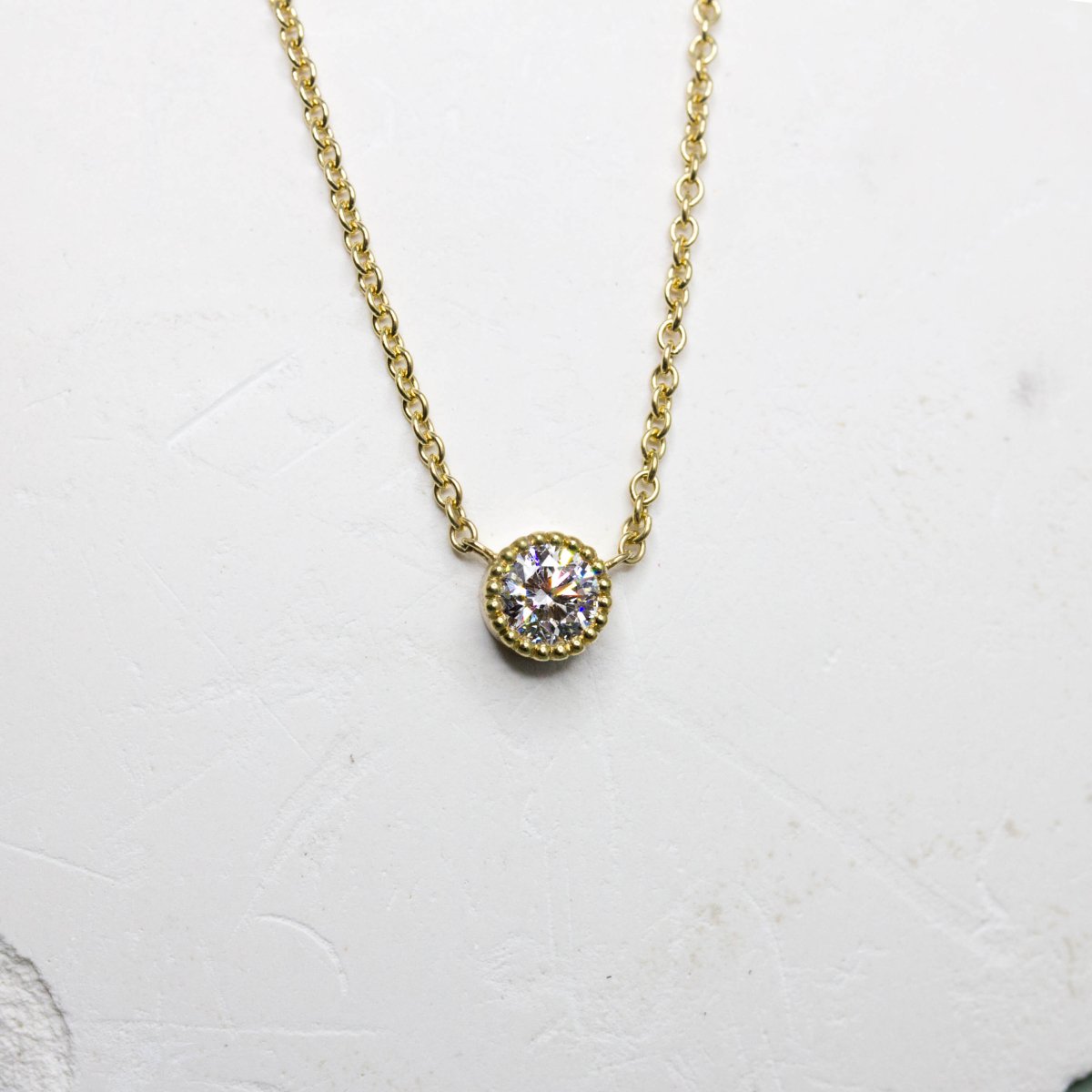 Collier artisanal en or jaune 18 carats Fairmined, orné d'un diamant de synthèse.