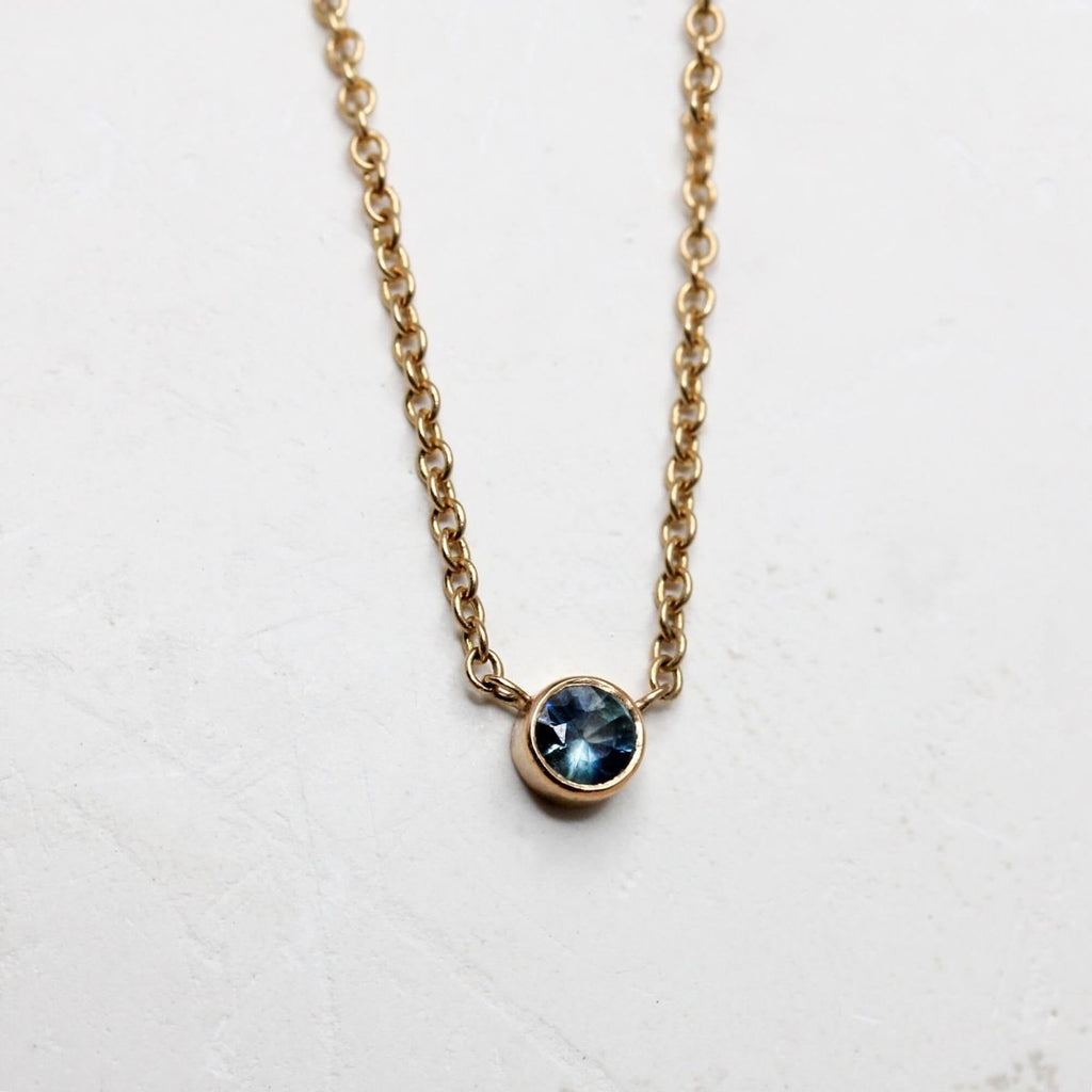 Collier artisanal en or 18 carats Fairmined orné d'un saphir bleu.